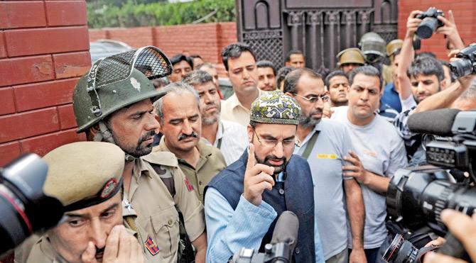 Chairman of a moderate faction of the All Parties Hurriyat (Freedom) Conference Mirwaiz Umar Farooq (C) speaks outside his home before being detained by the police at Nigeen in Srinagar yesterday. Pic/AFP