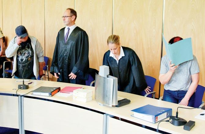 Andrea (right) and her husband Johann (left) stand next to their lawyers before their trial yesterday. Pic/AFP
