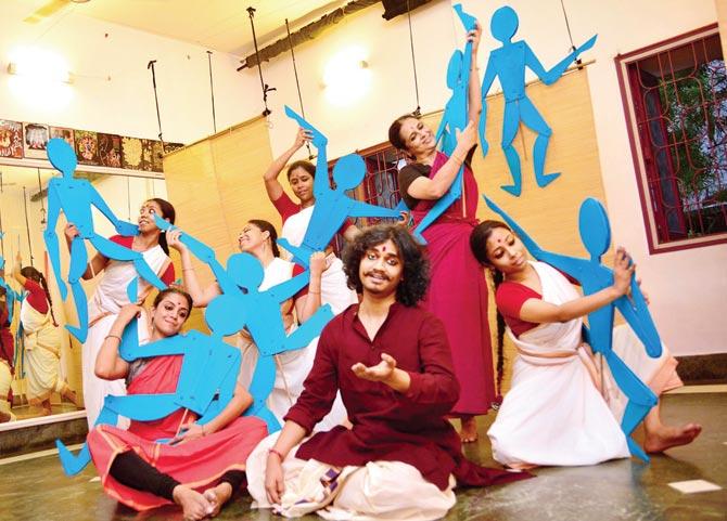 Music director and performer Srijan Chatterjee (center) with dancers at a rehearsal