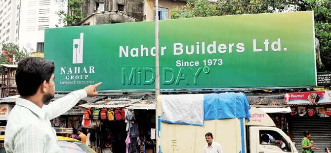 Champak Zaveri’s representative points to the hoarding which Zaveri claims has been taken over by Nahar builders, at Tardeo. Pic/Datta Kumbhar