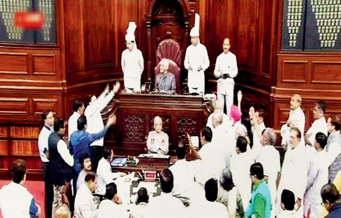 Opposition members near the chairman’s podium, raising slogans against the government. Pic/PTI