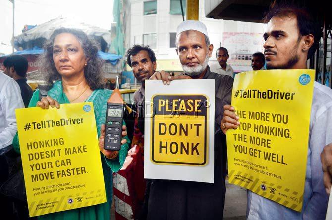 Sumaira Abdulali (left) showing the reading of the noise meter at JJ Hospital junction with others holding placards. Pic/Sneha Kharabe