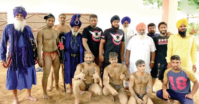Team Relentless (seated) with Yadvinder Singh (standing, second-right) and Punjabi wrestlers