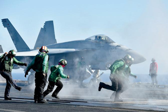 Sailors get ready around an F/A-18E Super Hornet on the US Navy’s super carrier USS Dwight D Eisenhower in the Mediterranean Sea. The aircraft carrier is deployed in support of Operation Inherent Resolve, conducting strikes against terrorist group ISIL in Libya, Iraq and Syria. Increasing terror attacks are denting confidence in the markets. Pic/AFP