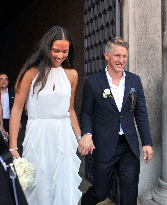 Bastian Schweinsteiger and Ana Ivanovic leave the hall after the wedding