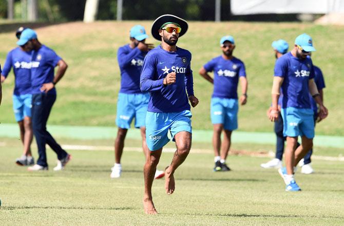  Shikhar Dhawan (C) runs bare foot with his teammates during a practice session at the Warner Park stadium in Basseterre, Saint Kitts, on Wednesday.