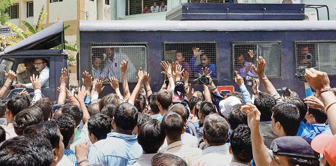 Family members wave to the convicts as they are taken away after the verdict by a special SIT court in Ahmedabad yesterday. Pics/PTI