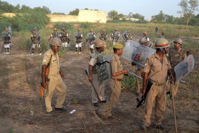 Police stand guard during clashes with encroachers in Mathura. Pic/ AFP