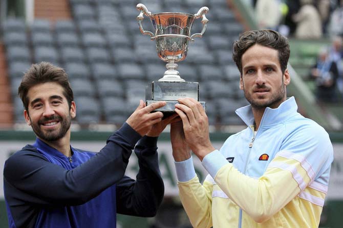 Feliciano Lopez (R) and Marc Lopez hold their French Open trophy. Pic/ PTI