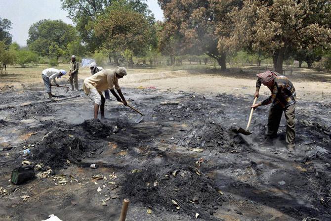 Workers clearing the ashes inside the clash-hit Jawahar Bagh in Mathura on Tuesday. PTI Photo