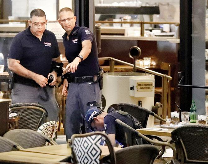 Israeli security forces inspect a restaurant following the attack