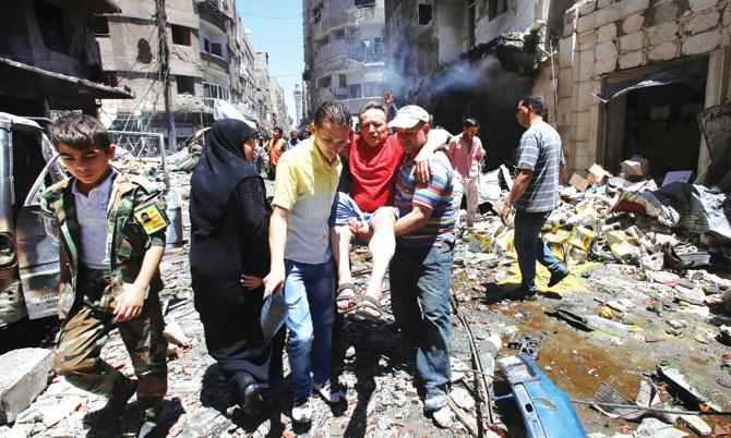 A wounded man is carried at the scene of a double bombing attack  outside the Sayyida Zeinab shrine, Damascus. Pic/AFP