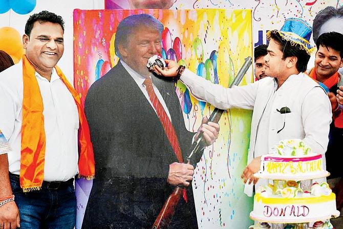 Hindu Sena chief Vishnu Gupta feeds cake to Trump’s poster. pic/PTI 