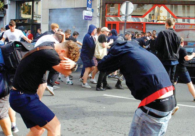 English supporters take evasive action as French police use pepper spray on them in Lille, France on Wednesday. Pic/AP