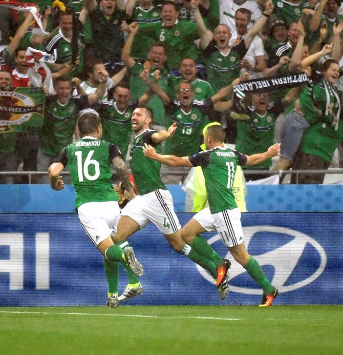 Northern Ireland-s defender Gareth McAuley C celebrates with Northern Ireland-s forward Conor Washington r and Northern Ireland-s midfielder Oliver Norwood after scoring the opening goal during the Euro 2016 group C football match between Ukraine and Northern Ireland at the Parc Olympique Lyonnais stadium in Décines-Charpieu near Lyon. Pic/AFP