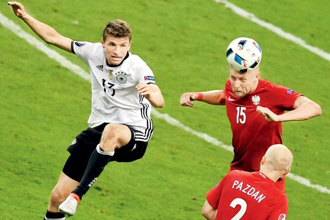 Poland’s Kamil Glik heads the ball away from Germany’s Thomas Mueller (left) during their Euro Group C clash on Thursday. Pic/AFP