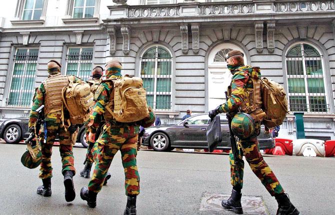 Belgian soldiers walk the streets after the dismantling of a new terrorist unit last night, in Brussels. Pic/AFP
