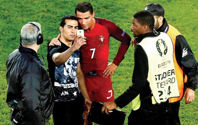 Cristiano Ronaldo clicks a selfie with a Portugal fan after the match.