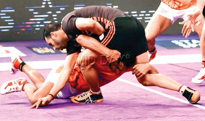 U Mumbai captain Anup Kumar is captured by a Puneri Paltan defender during a Pro Kabaddi League match at NSCI Stadium, Worli yesterday. Pic/Atul Kamble