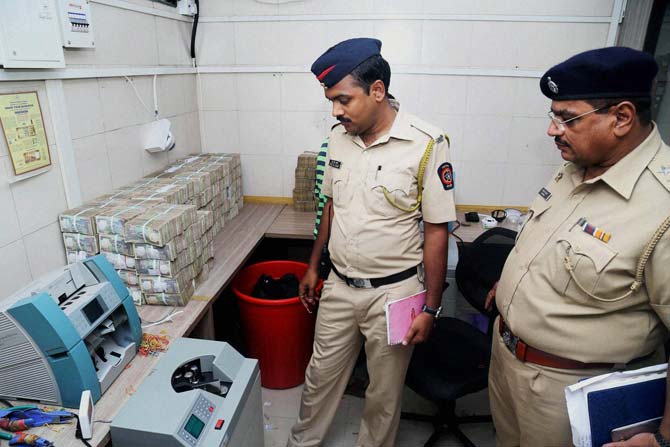 Police investigate after robbery at a cash management firm in Thane. Pic/ PTI
