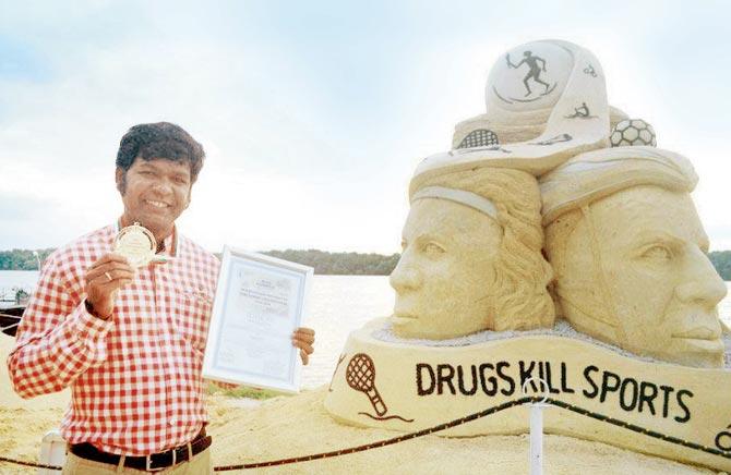Sudarsan Pattnaik tweeted a photo of him set against his award-winning "Drugs Kill Sport" sculpture