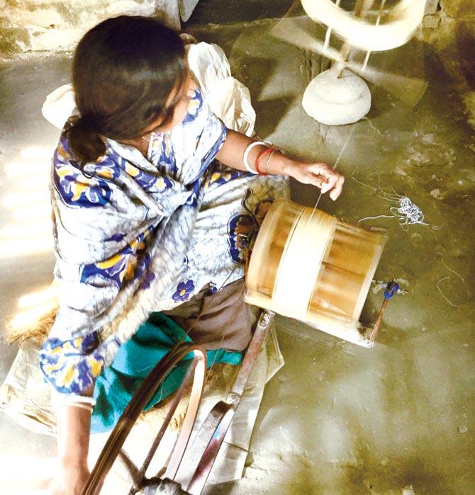 An artisan spins Eri silk yarn to make handwoven clothes for The Plavate