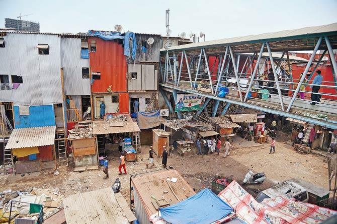 The slums in Bandra East, packed close to each other, bear down on the skywalk. A number of them have been rented out for commercial use. File pic