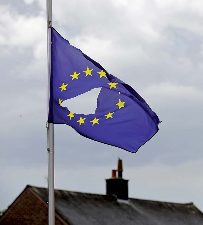 A European Union flag, with a hole cut in the middle, flies at half-mast outside a home in Knutsford, UK. Pic/Getty images