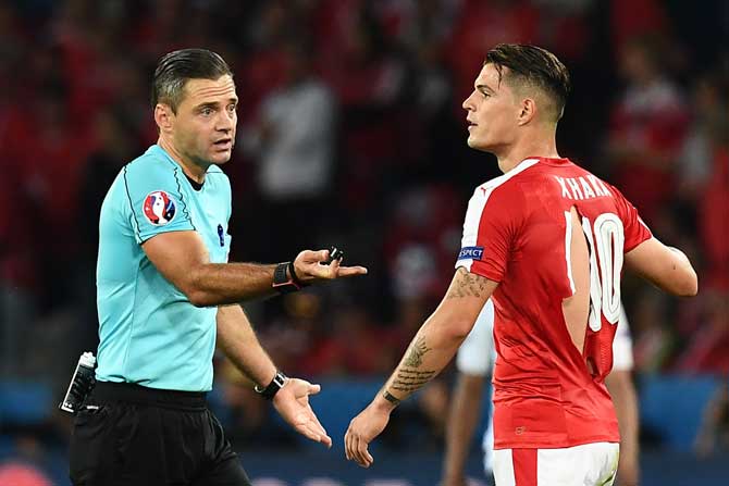 Slovenian referee Damir Skomina gestures towards Switzerland