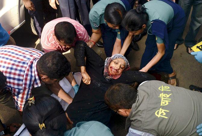 The dead body of Mahmuda Aktar, the wife of a top Bangladeshi anti-terror officer, is lifted up by police. Pic/AFP
