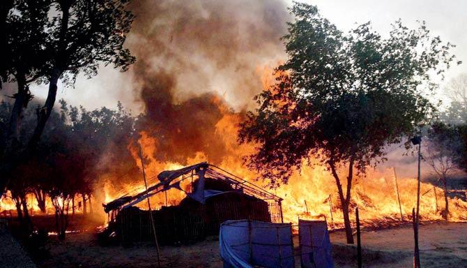 Several huts caught fire during the clash between police and encroachers from Jawahar Bagh on Thursday. Pics/AFP and PTI