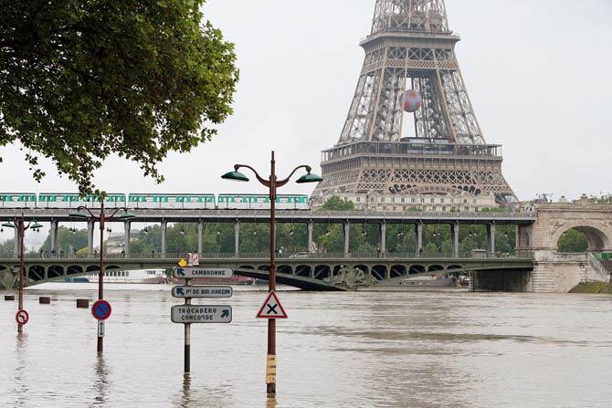 A part of the Eiffel tower and a subway crossing a bridge over the river Seine after its banks became flooded following heavy rainfalls. Pic/AFP