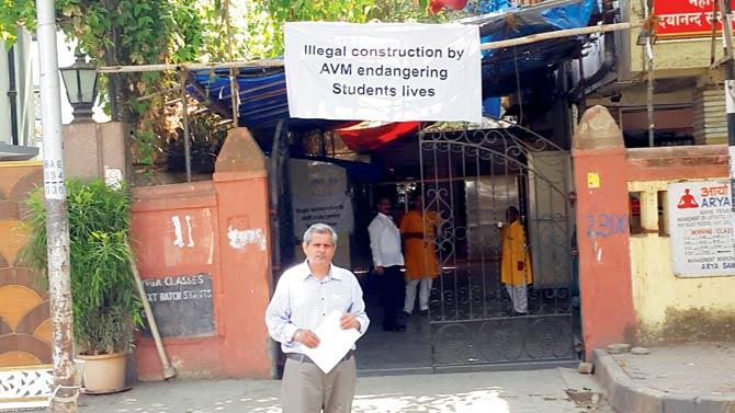 Secretary of the trust, Sangeet Sharma outside the school, where some trustees have put up banners saying the construction is illegal