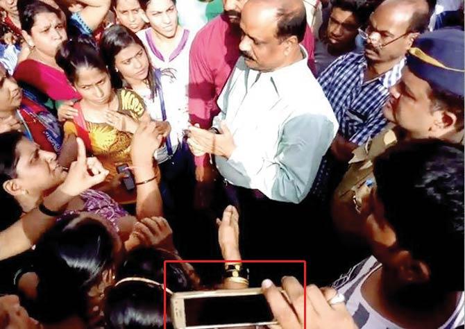 These two grabs from the new video show a person holding a mobile (left, circled), which Sarvankar claimed emitted a light that disturbed him, and he raised his hand towards the light