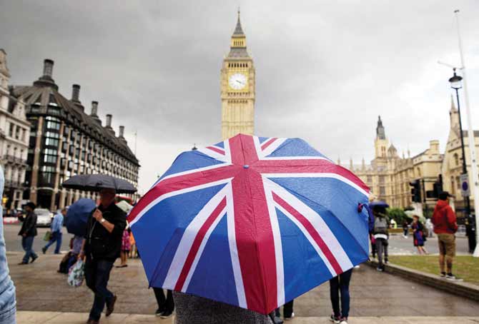 No shelter, soon: A pedestrian shelters from the rain beneath a Union flag themed umbrella near the Big Ben clock face and the Elizabeth Tower at the Houses of Parliament in London. Pics/AFP