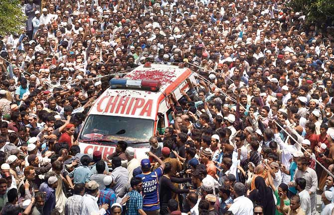 Pakistani mourners gather around an ambulance carrying the coffin of Sufi musician Amjad Sabri during his funeral in Karachi yesterday.