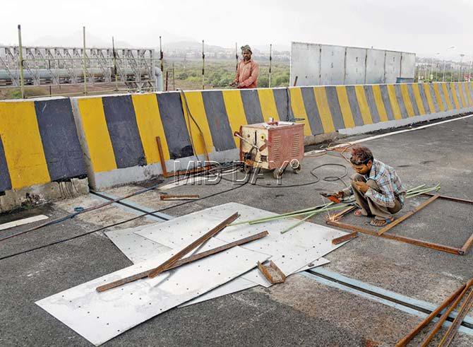 MMRDA ostensibly put labourers to work installing view-cutters along the Vasai flyover yesterday, a day after mid-day pointed out that there were no signs of work being carried out there. Pics/Hanif Patel