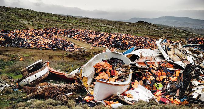 Wrecked boats and life jackets used by refugees during their journey across the Aegean sea lie in a dump in Greece