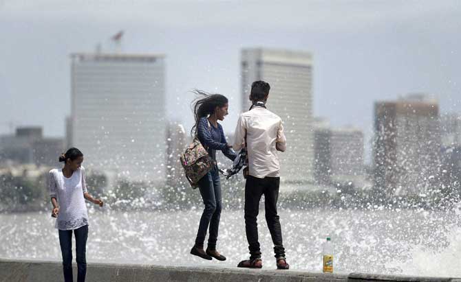 A young couple enjoy the high tide at Marine Drive on Wednesday. Pic/PTI