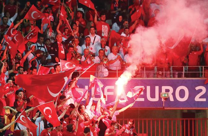 Turkey supporters wave the national flag and a flare during the match against Spain in Nice on Friday. Pic/AFP