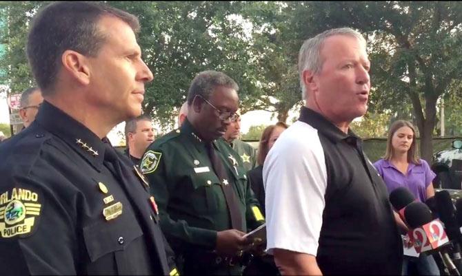 Orlando, Florida Mayor Buddy Dyer (R) speaking at a press conference following a mass shooting at the Pulse Night Club as police chief John Mina looks on. AFP PHOTO / Orlando Police Department