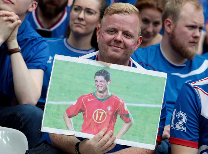 An Iceland supporter holds a picture depecting Portugal