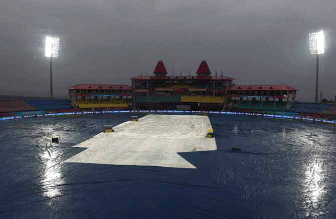 The ground is covered as it rains during the T20 World Cup match between Oman and Netherlands in Dharamshala. Pic/PTI