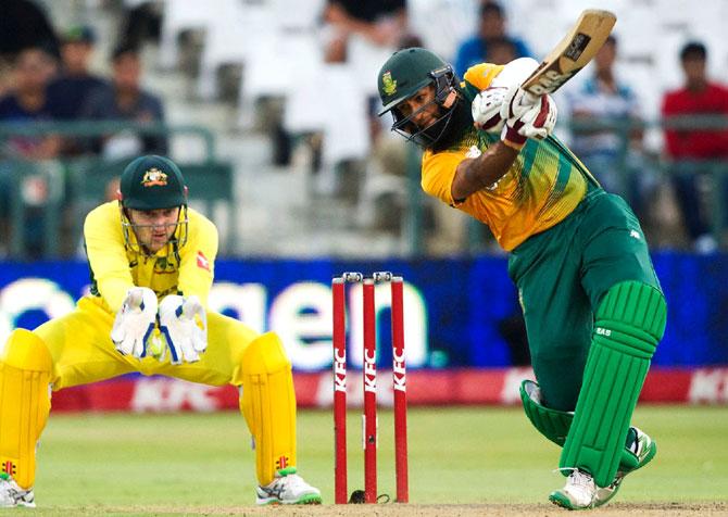 South African batsman Hashim Amla (R) plays a shot while Australian wicket keeper Peter Nevill keeps watch during the third and final T20 cricket match between South Africa and Australia at the Newlands Stadium in Cape Town. Pic/AFP