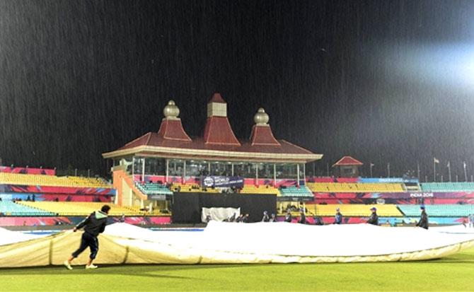 Groundsmen cover the pitch as its raining during the T20 world cup match between Bangladesh and Ireland in Dharamshala. Pic/PTI
