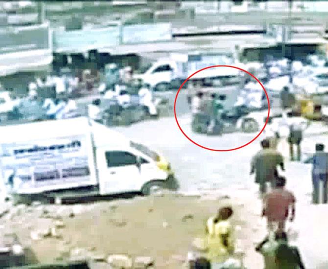 Attackers leave the spot on a bike (circled) after murdering Shankar 