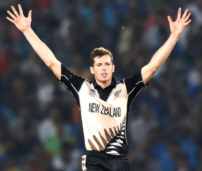 New Zealander bowler Mitchell Santner celebrates after the wicket of India