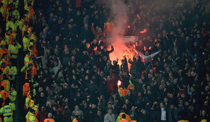 Flares are lit by the Liverpool supporters during the UEFA Europa League round of 16, second leg football match between Manchester United and Liverpool at Old Trafford in Manchester, north west England. Pic/AFP