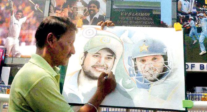 An artist paints a portrait of India skipper MS Dhoni and Pakistan captain Shahid Afridi outside Eden Gardens on the eve of Indo-Pak tie in Kolkata yesterday. Pic/PTI