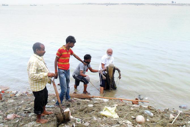 Chandra and helpers fish out a corpse from the Ganga